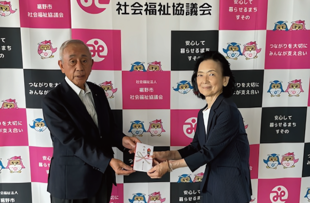 7月10日：「裾野市社会福祉協議会へ寄付」 裾野市民文化センター入口設置「愛の募金だる」（前年度 鈴木会長と裾野市社会福祉協会 杉山会長）